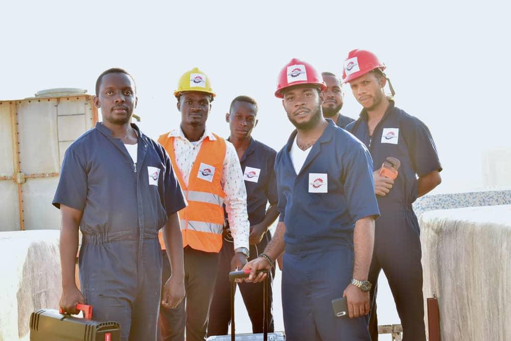 BOL Engineering technicians in branded workwear and hard hats on a rooftop