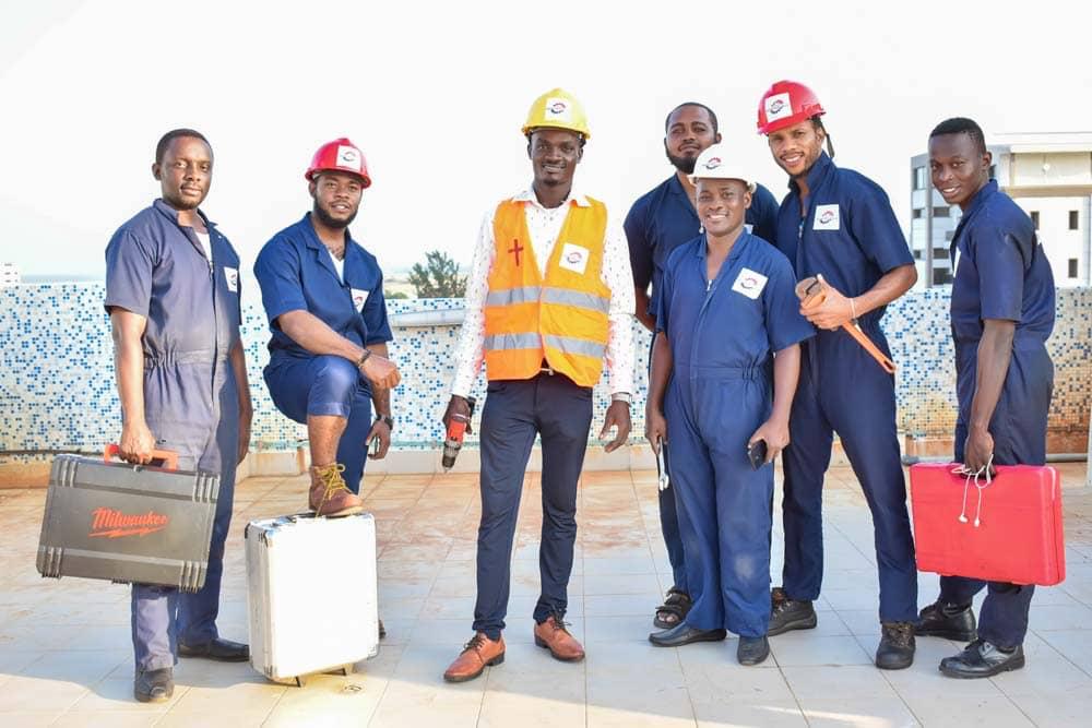 BOL Engineering team in branded coveralls, hard hats and a hi-vis vest with tool cases on a rooftop